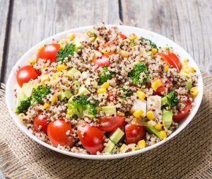 sałatka z tofu, brokułem, komosą ryżową i pomidorkami koktajlowymi, podana w miseczce.