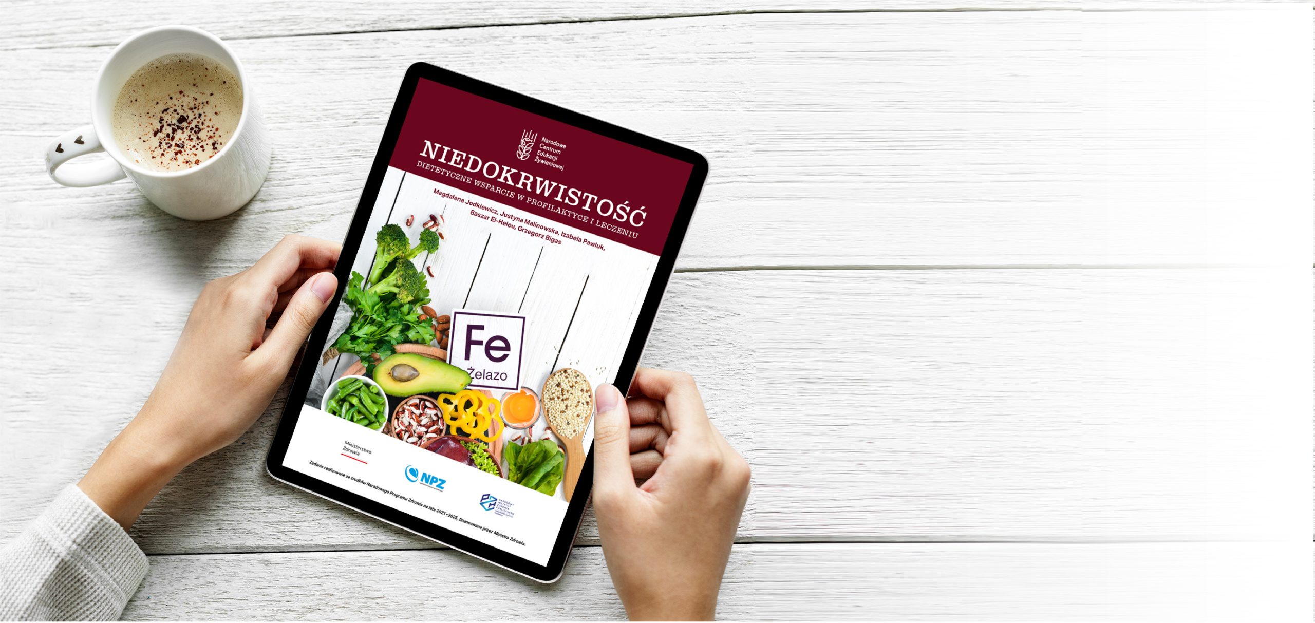 Kobieca ręka trzymająca tablet z wyświetlającą się na nim okładką ebooka o niedokrwistości